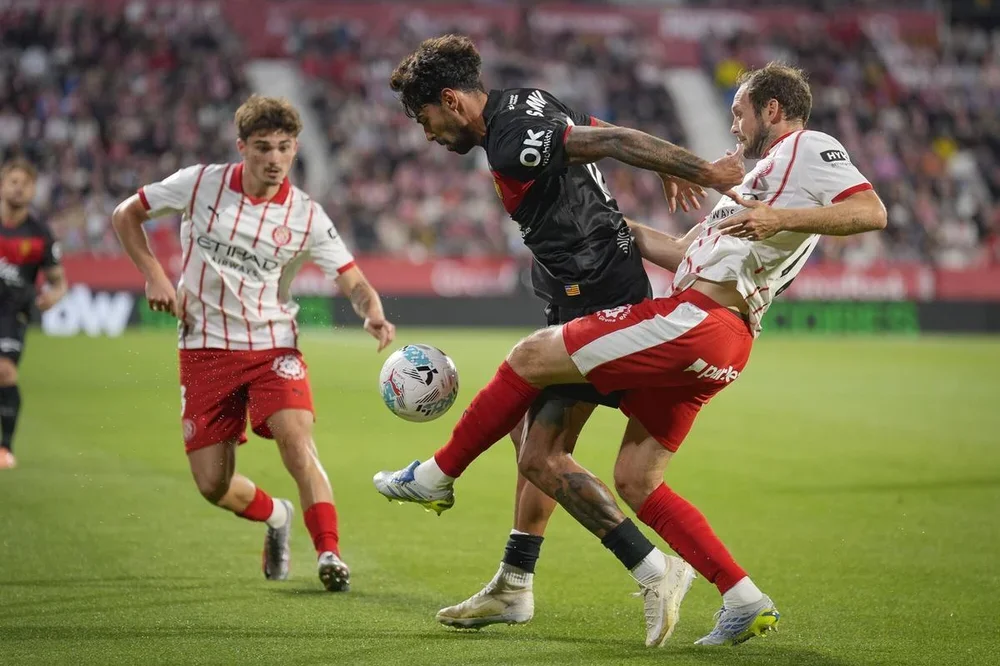 El centrocampista portugués del Mallorca Samu Costa (2d) pelea un balón con el defensa neerlandés del Girona Daley Blind (d) durante el partido de La Liga de fútbol entre el Girona FC y RCD Mallorca, este viernes en el estadio municipal de Montilivi. EFE/David Borrat.. (Girona) (Mallorca)